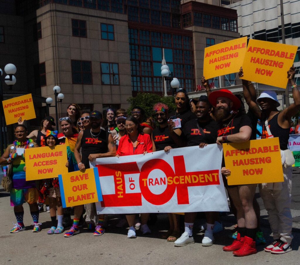 HOT in cleveland pride marching holding signs for affordable hausing and saving the planet (climate change) and more